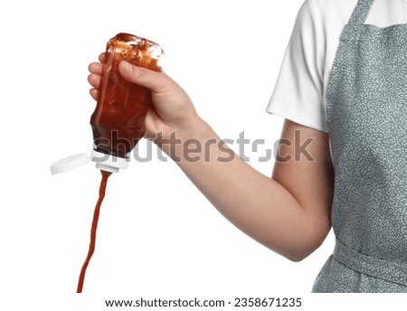 Woman pouring tasty ketchup from bottle on white background, closeup