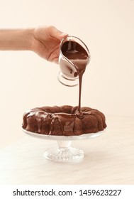 Woman Pouring Tasty Sauce On Chocolate Cake