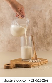 A Woman Pours Oat Milk Into A Mug. Alternative Milk. Copy Space.