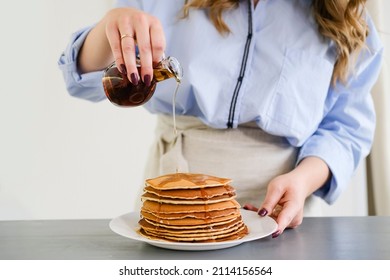 A woman pours pancakes with syrup. No face, close up. bright kitchen. - Shutterstock ID 2114156564