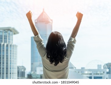 Woman Power And Girl Strength In Business Achievement, Winning And Career Success With Strong Businesswoman Leader In Office Raising Fists With Ambition Looking Forward To City Building Background 