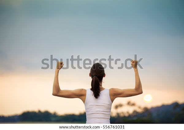 Woman power! Strong and confident woman flexing her\
muscles. 