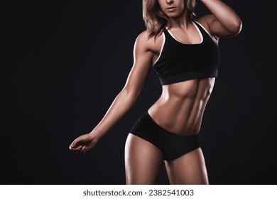 Woman with a powerfully muscular body, with a spotlight on her defined waistline showcasing strong abs. - Powered by Shutterstock