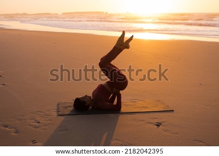 Woman practice balance asanas during the summer yoga session on beautiful beach