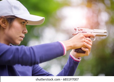 woman in practice shooting gun in martial arts for self defense in an emergency case