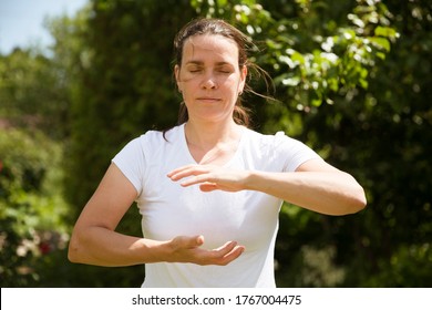 Woman practice Tai Chi Chuan in a park.  Chinese management skill Qi's energy. solo outdoor activities. Social Distancing 