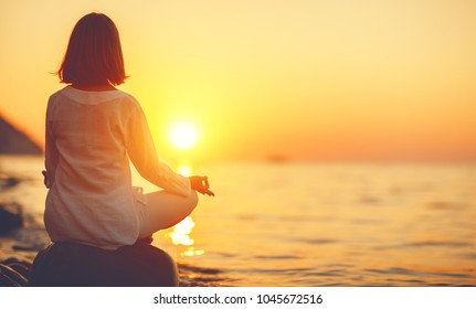 woman practices yoga and meditates in the lotus position on sunset beach
 - Powered by Shutterstock