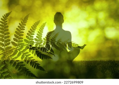 Woman practices yoga and meditates in the lotus position in green nature setting. Concept of meditation, dreaming, wellbeing and healthy lifestyle - Powered by Shutterstock