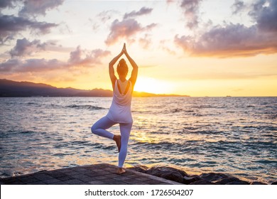 Frauen praktizieren Yoga an der Küste
