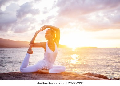 Woman practices yoga at seashore - Powered by Shutterstock