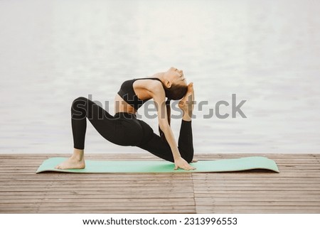 Similar – Active slim young woman doing yoga by the lake