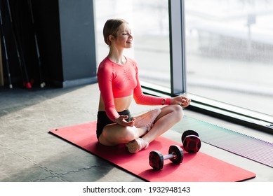 Woman practicing advanced yoga on mat against a large window