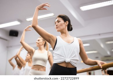 Woman practicing ballet elements in dance class - Powered by Shutterstock