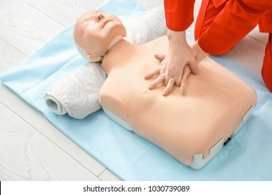 Woman Practicing CPR On Mannequin At First Aid Class