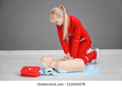 Woman Practicing CPR On Mannequin At First Aid Class