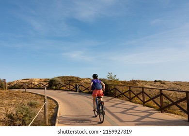 Woman Practicing Cycling On A Bicycle Lane By The Sea In Palma De Mallorca (Balearic Islands, Spain)