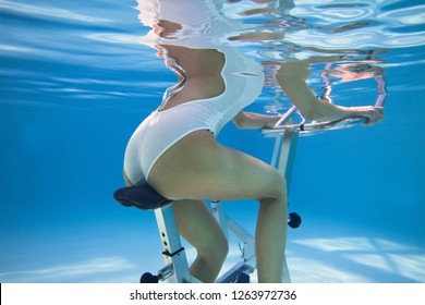 Woman Practicing Cycling In A Pool