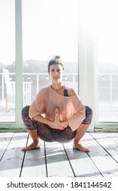 Woman Practicing Garland Pose During Her Yoga Class