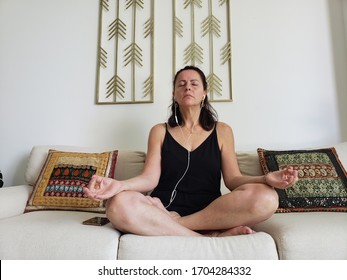 Woman Practicing A Guided Meditation In Her Living Room