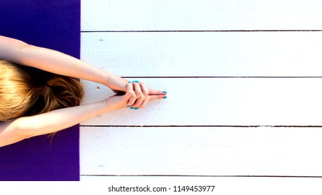 Woman Practicing Outdoors On Violet Yoga Mat. Overhead Close Up Of Female Hands In Mudra On White Wooden Background