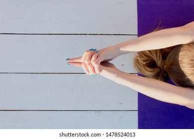 Woman Practicing Outdoors On Violet Yoga Mat. Overhead Close Up Of Female Hands In Mudra On White Wooden Background