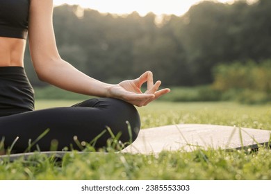 Woman practicing Padmasana on yoga mat outdoors, closeup and space for text. Lotus pose - Powered by Shutterstock