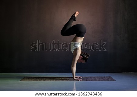 woman practicing yoga, Adho Mukha Vrksasana exercise, Downward facing Tree pose