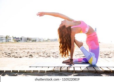 Woman Practicing Yoga At The Beach