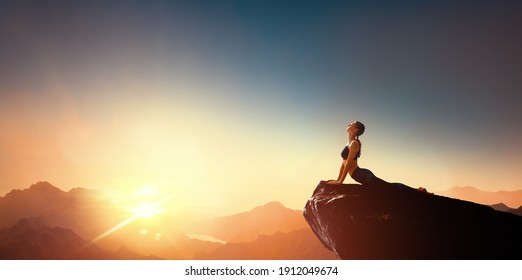 Woman practicing yoga and meditates on the mountain.