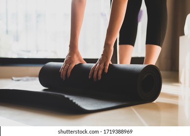 Woman Practicing Yoga And Meditating Indoors. Beautiful Girl Preparing Material For Practice Class. Calmness And Relaxation. Female Happiness And Yoga Concept.