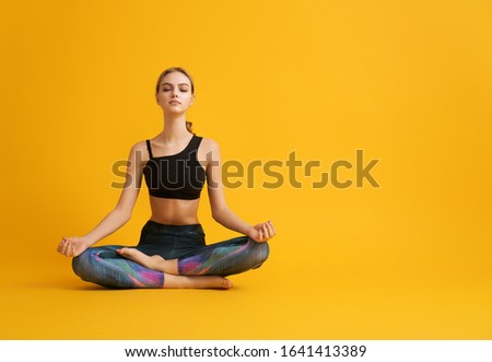 Woman is practicing yoga and meditation on color background.