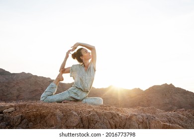 Frauen, die in den Bergen der Wüste Yoga praktizieren