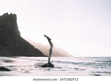 Woman practicing yoga on the beach at sunset or sunrise. Beautiful fit girl in white clothes doing yoga on coastline on nature background of the ocean. Travel, Meditation, Freedom, Healthy Lifestyles. - Powered by Shutterstock