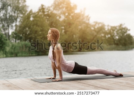 Similar – Active slim young woman doing yoga by the lake