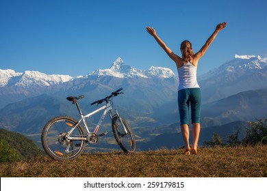 Woman practicing yoga, relaxing after riding bikes high in mountain