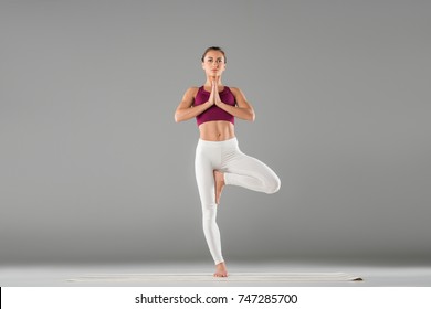woman practicing yoga, standing in tree exercise, Vrksasana pose
