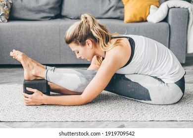 Woman Practicing Yoga Use Block At Home.