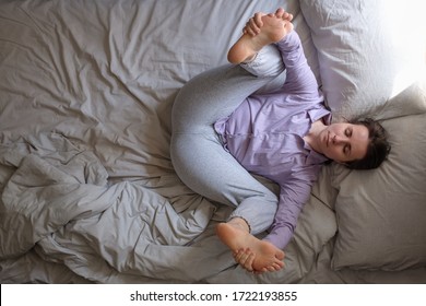 Woman Practicing Yoga, Working Out, Doing Happy Baby Dead Bug Pose, Ananda Balasana, Relaxing, Stretching Spine, Legs, Relieving Back Pain In The Bed In The Morning