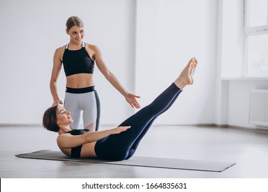 Woman Practising Yoga At The Gym With The Trainer