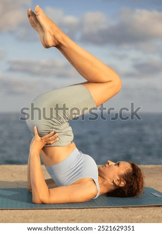 Similar – Image, Stock Photo Flexible woman performing headstand pose in yoga studio