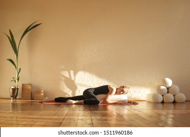 Woman practiving restorative yoga in a beautiful studio