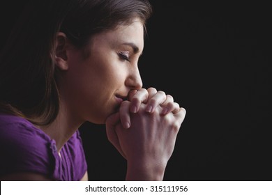 Woman Praying With Hands Together On Black Background