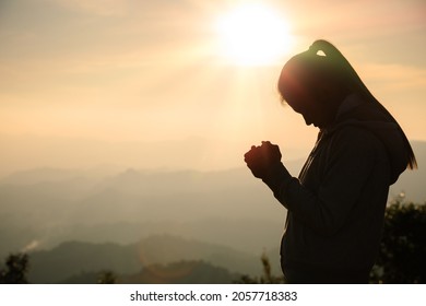 woman praying in the morning concept of christianity rising sun background Concept of prayer, faith, hope, love, liberation.