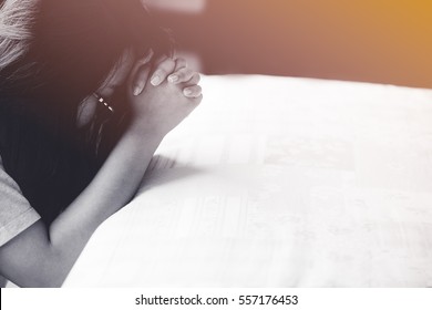 woman praying on the bed in the morning.teenager woman hand with Bible praying,Hands folded in prayer on the bed in the morning concept for faith, spirituality and religion.black and white tone.