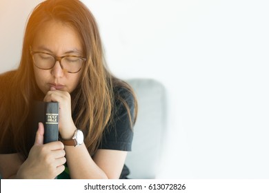woman praying on holy bible in the morning.teenager woman hand with Bible praying,Hands folded in prayer on a Holy Bible in church concept for faith, spirituality and religion.
