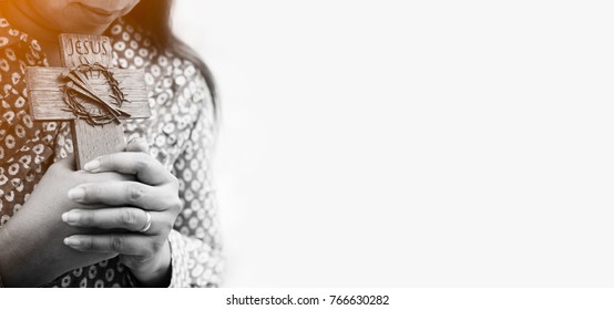 woman praying on holy cross in the morning.teenager woman hand with cross praying,Hands folded in prayer in church concept for faith, spirituality and religion.black and white. - Powered by Shutterstock