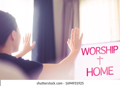 Woman praying and worship to GOD with church online sunday service.Live Church with bible.Woman raise hands for praise and worship the LORD.Home church.Quarantine from Covid-19 Coronavirus pandemic
