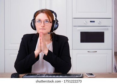 A Woman Prays To God At A Computer During Isolation Due To A Coronavirus. Religion And Confession In Online Video Call To The Priest Of The Church Under Quarantine