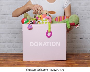 Woman Prepare To Donate Toys In Charity Shop