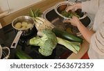 A woman prepares fresh vegetables for cooking, promoting healthy eating habits and home cooking.